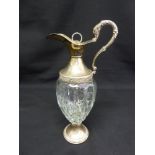 A cut glass and silver plated claret jug with serpentine handle and hinged cover