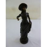 A bronze figurine of a lady wearing a hat in 18th century dress, 31.5cm (h)