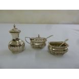 A silver three piece condiment set with two condiment spoons,