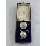A cased silver strawberry set comprising sugar bowl, cream jug and sugar tongs, Birmingham 1920