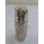 A silver sugar sifter, cylindrical with pierced screw off cover, profusely chased with flowers and