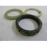 Three jadeite bangles with 14ct gold clasps and mounts