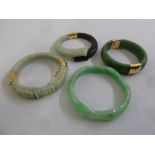 Four jadeite bangles with 14ct gold clasps and mounts