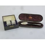 A cased pair of silver napkin rings and a silver spoon in fitted case