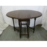 An oak drop flap gate leg table with barley twist legs