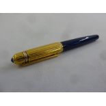 A Pasha de Cartier roller ball pen in blue with gold plated ribbed cover set with a cabochon