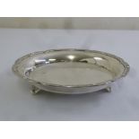 A circular silver cake basket with Celtic border on three bracket feet, London 1939