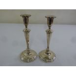 A pair of silver table candlesticks, panelled tapering cylindrical stems on raised circular bases,