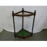 An early 20th century oak corner umbrella stand with barley twist columns