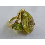 A heart shaped green quartz ring set in 18ct gold with peridot to the shoulders, approx total weight