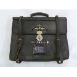 An RAF briefcase with leather straps, applied RAF wings and decorations with central carrying