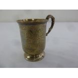 A Victorian silver Christening mug chased with flowers and leavers, double scroll handle on circular