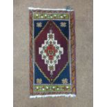 A wool prayer rug red ground with central geometric motif, 95 x 51cm