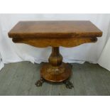 A Victorian mahogany games table on pedestal base with claw feet
