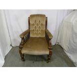 A Victorian mahogany upholstered button back armchair with galleried sides on four turned legs