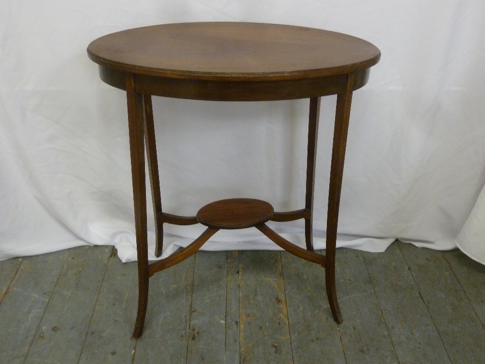 An Edwardian oval side table on four tapering legs