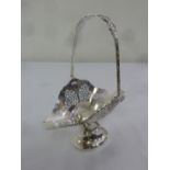 A white metal bonbon basket, pierced sides with scroll chased swing handle on raised oval base