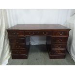 A mahogany partners desk with tooled leather top, nine drawers with brass handles