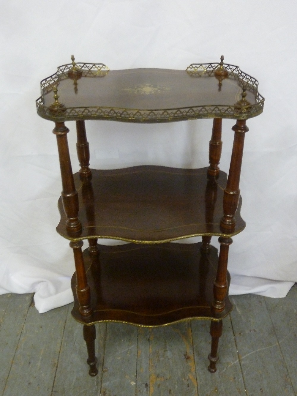 A French mahogany and brass three tier whatnot on turned tapering cylindrical legs