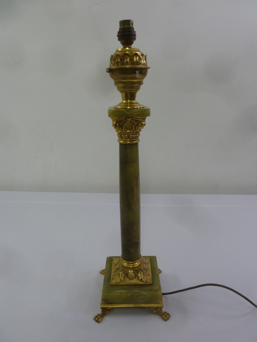 A gilt metal and onyx table lamp of Corinthian form on raised square base