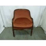 A mahogany upholstered occasional chair on turned tubular legs