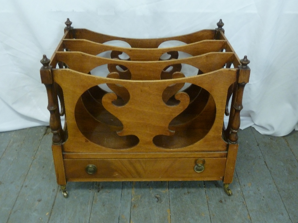 An early 20th century mahogany Canterbury scroll pierced sides on four brass castors