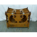 An early 20th century mahogany Canterbury scroll pierced sides on four brass castors