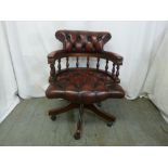 A red leather captains chair of customary form on castors