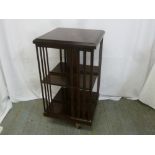 A mahogany revolving Canterbury with slatted sides on original casters, A/F
