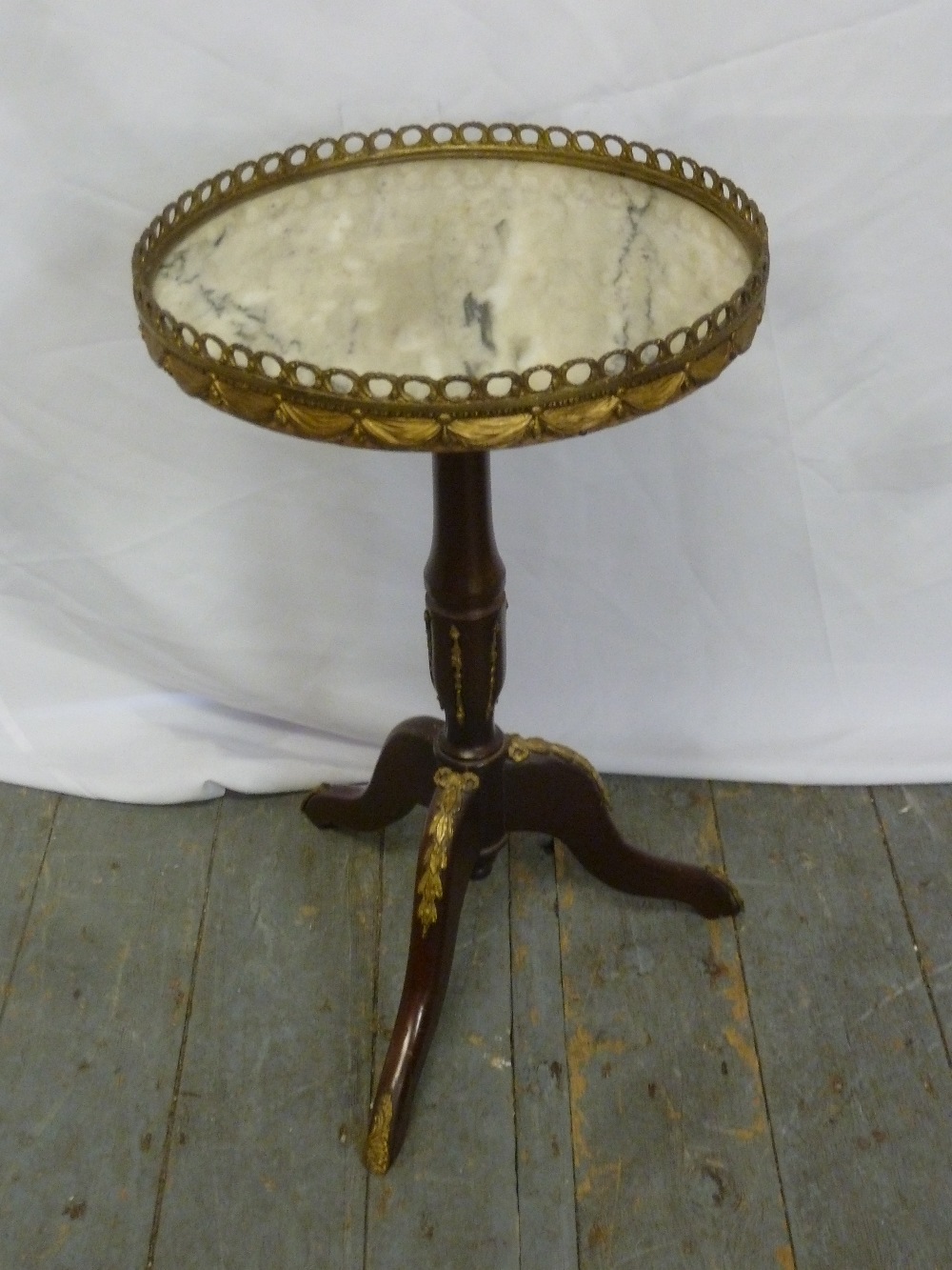 A circular mahogany and marble occasional table with gilt metal gallery on tripod base