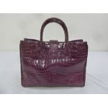 A ladies stained purple crocodile handbag