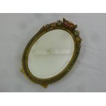 A mid 20th century oval carved wood and gesso table mirror