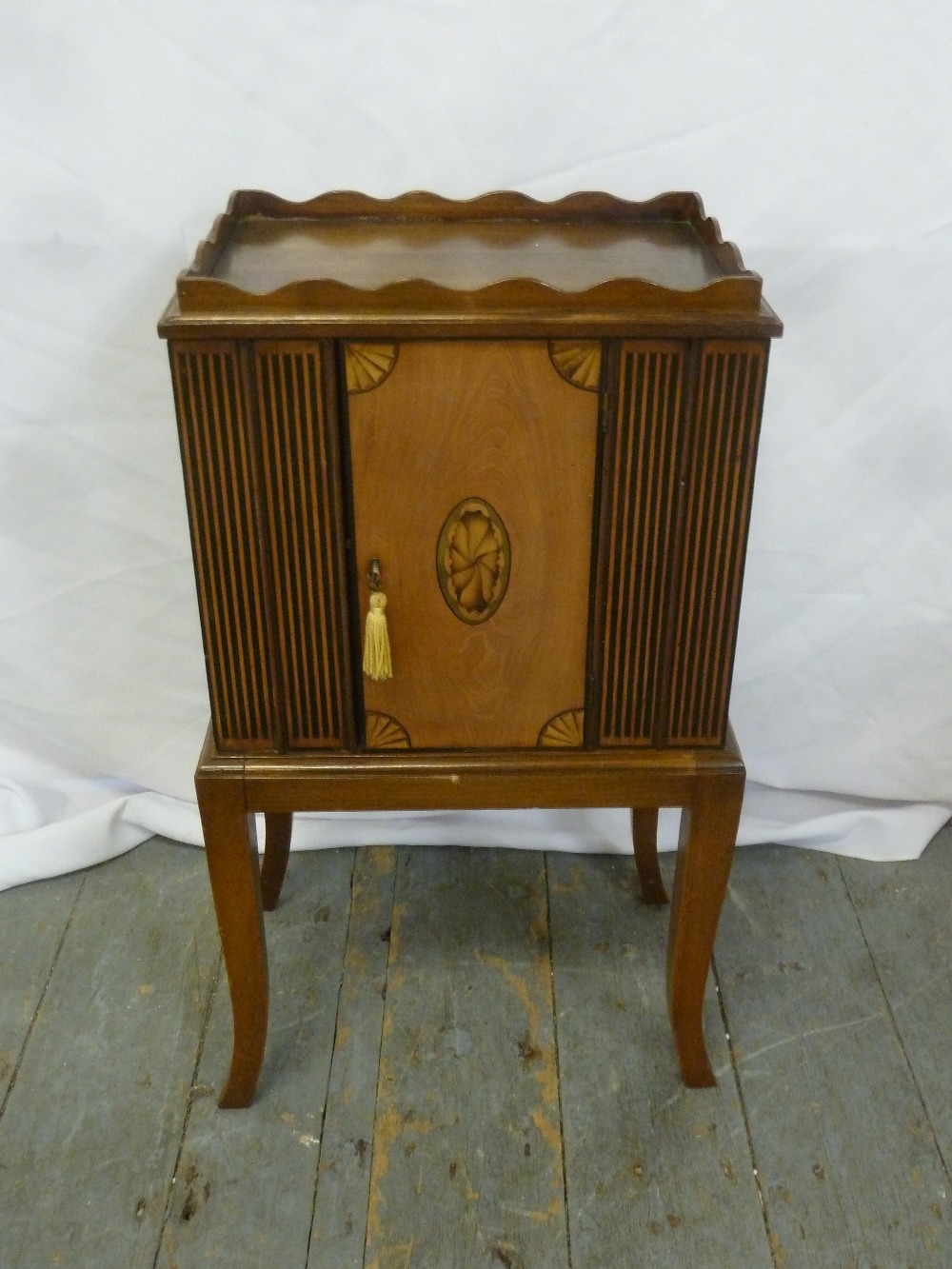 An Edwardian rectangular mahogany cupboard with drawers to one side and cupboard to reverse on