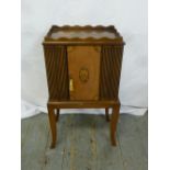 An Edwardian rectangular mahogany cupboard with drawers to one side and cupboard to reverse on