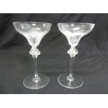 A pair of Lalique tall stem figural glasses on circular spreading bases, signed to the bases