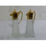Two gilded metal and cut glass claret jugs