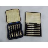A cased set of pastry forks and a cased set of butter knives