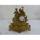 A French style gilded metal mantle clock surmounted by a female figure with white enamel dial and