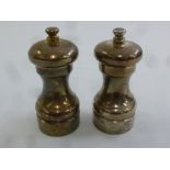 Two hallmarked silver pepper mills of customary form
