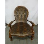 A Victorian mahogany button back upholstered armchair on four scroll legs