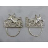 A pair of Victorian silver menu holders depicting hunting scenes and with hinged back struts, London