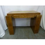 An Art Deco rectangular blonde oak veneered desk with tooled leather top and flanked by bookshelves