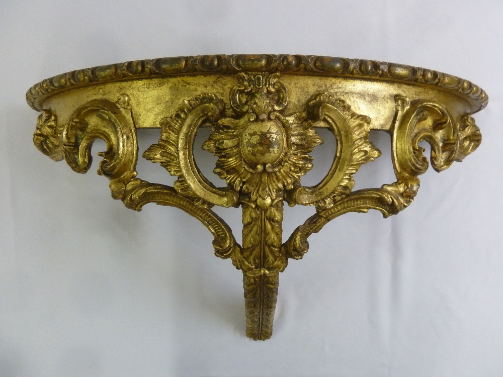 A gilded wooden carved and pierced demilune consol table
