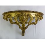 A gilded wooden carved and pierced demilune consol table