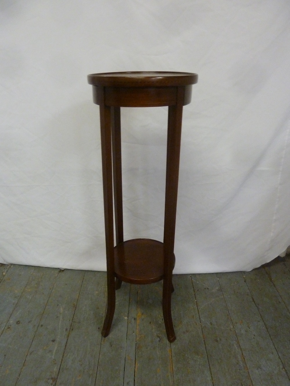 An Edwardian mahogany circular plant stand on four rectangular outswept legs