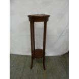 An Edwardian mahogany circular plant stand on four rectangular outswept legs