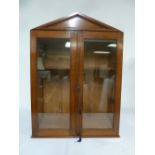 An Edwardian mahogany glazed wall mounted display cabinet with pediment top