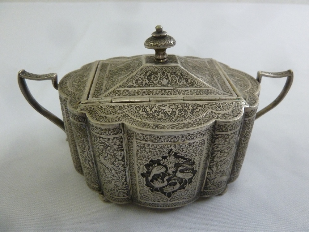 A Persian white metal sugar bowl and cover profusely engraved with birds, scrolls and vegetation,