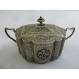 A Persian white metal sugar bowl and cover profusely engraved with birds, scrolls and vegetation,