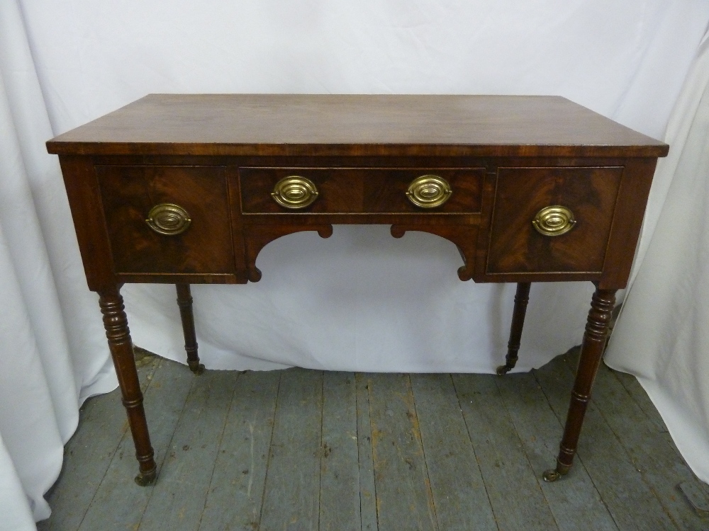 A Regency rectangular mahogany sideboard with brass handles on four turned cylindrical legs